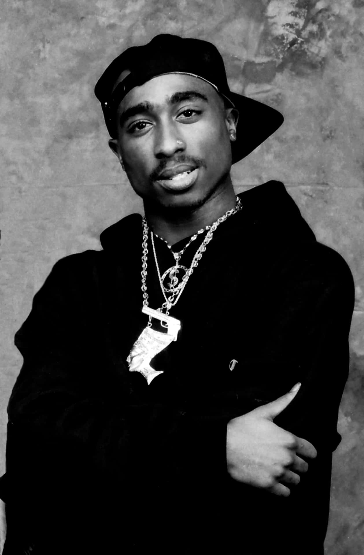 Tupac Shakur 在工作室肖像中戴著帽子和多條項鍊。 — Tupac GIF 壁紙