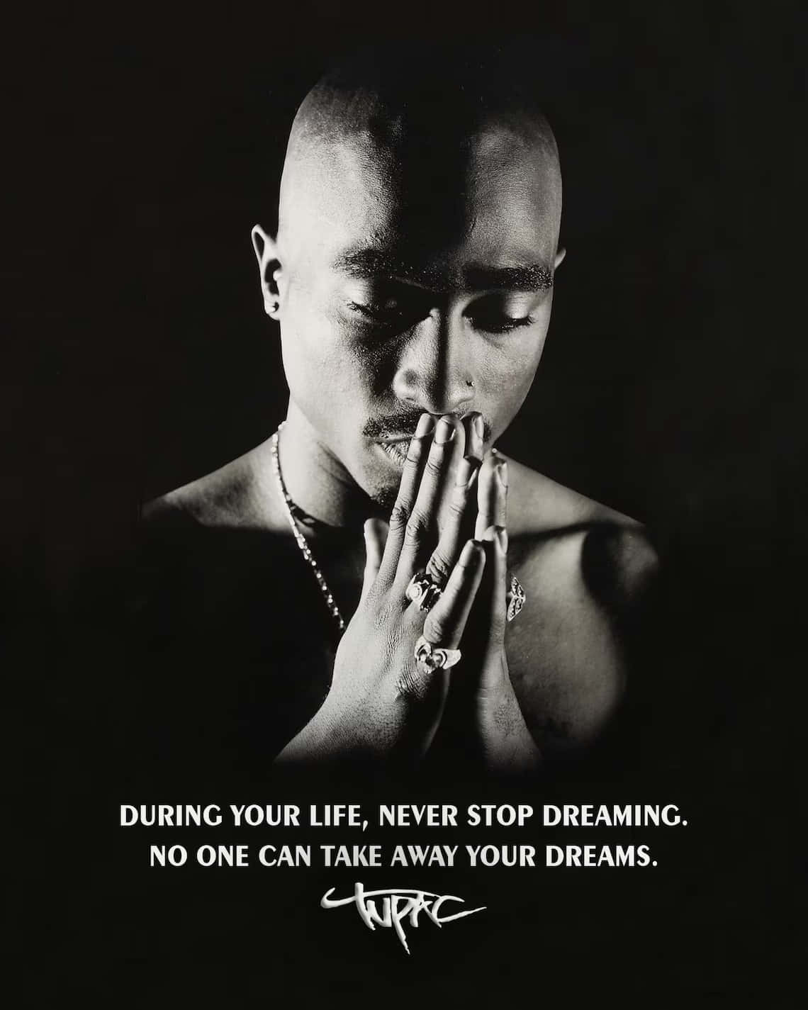 tupac 桌布 壁紙 — 一幅黑白肖像，Tupac Shakur 雙手合十放在嘴邊，背景深色，帶有勵志文字。