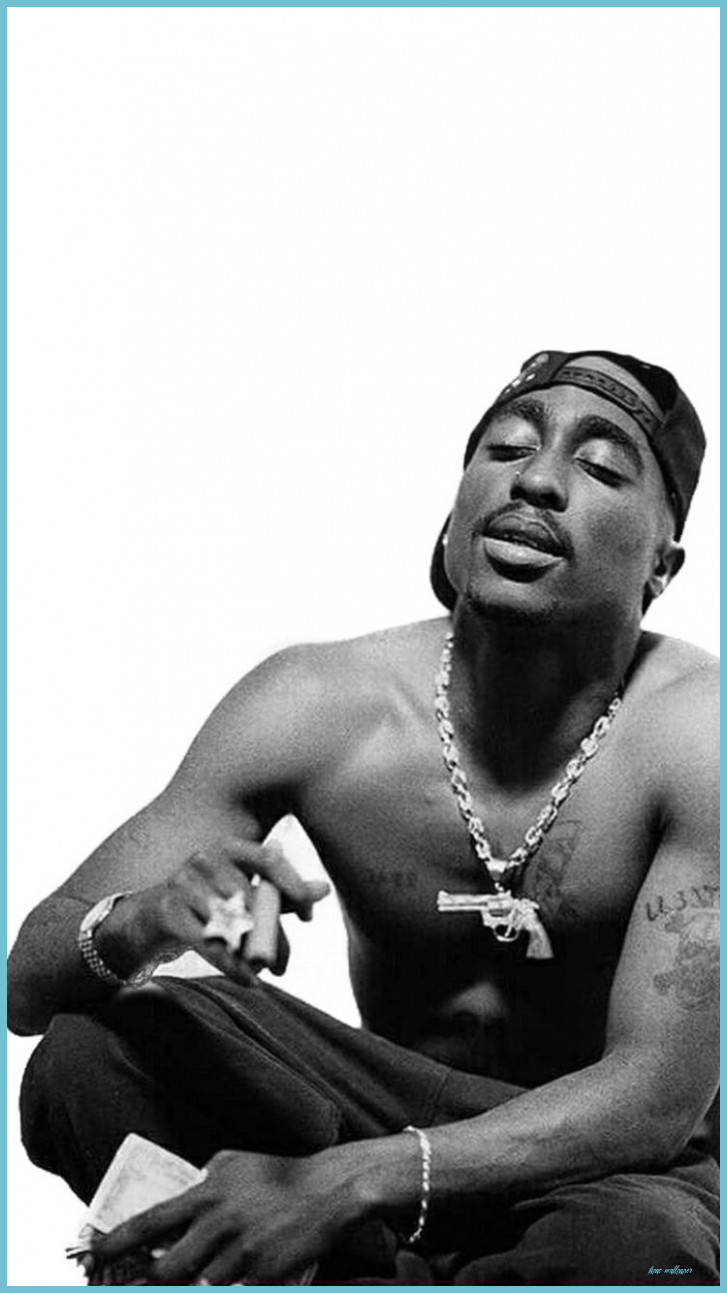 桌布 壁紙 — 一幅黑白肖像，Tupac Shakur 赤裸上身坐著，閉上眼睛，戴著鏈條和帽子，背景簡潔。