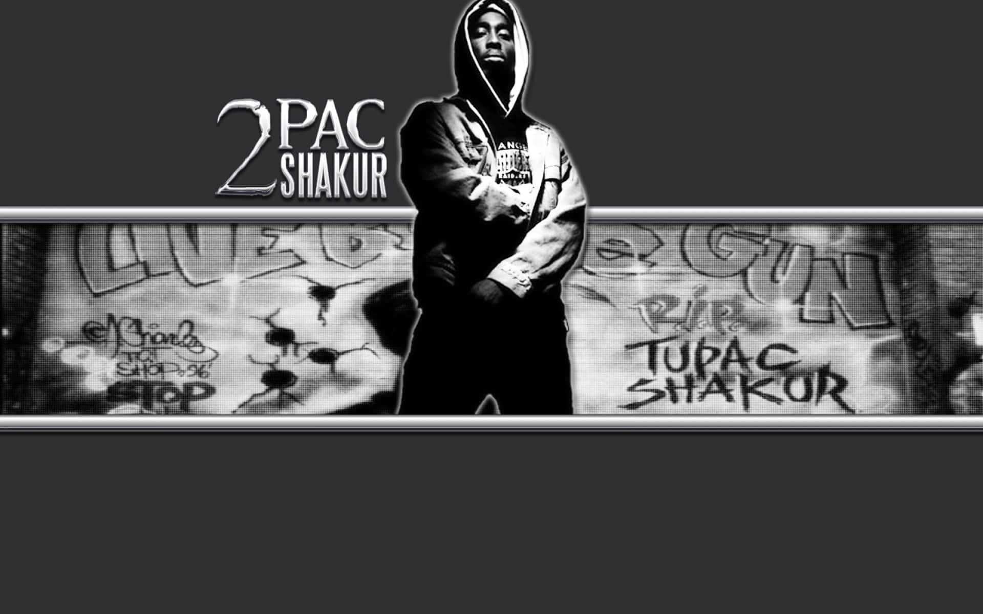 tupac 桌布 壁紙 — 一幅黑白肖像，Tupac Shakur 穿著連帽衫，站在佈滿塗鴉的牆前，牆上寫著「RIP TUPAC SHAKUR」。