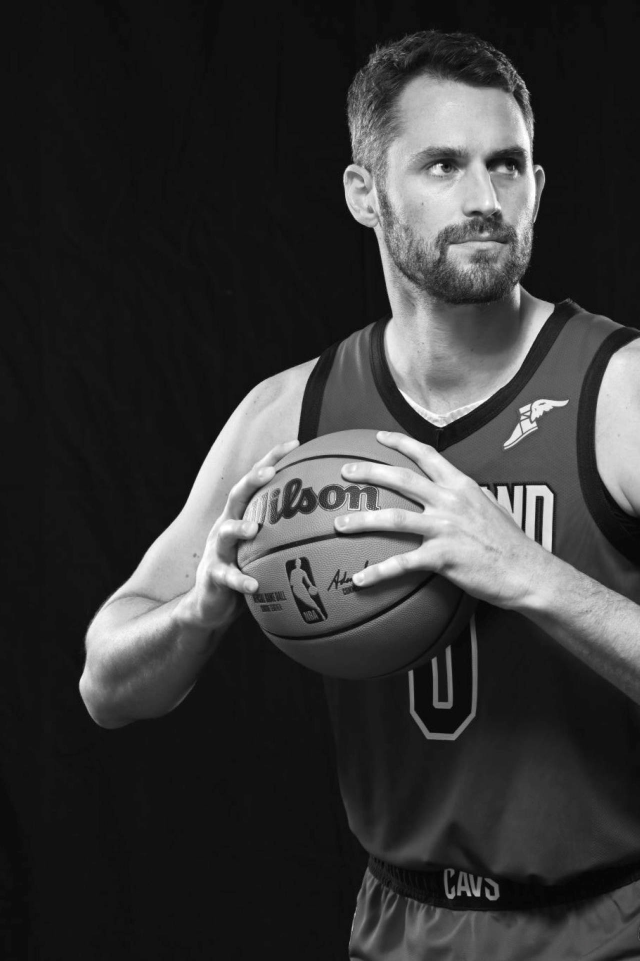 Kevin Love 桌布 壁紙 — 一幅黑白肖像，一名留鬍子的籃球運動員在黑暗背景下手持Wilson球。