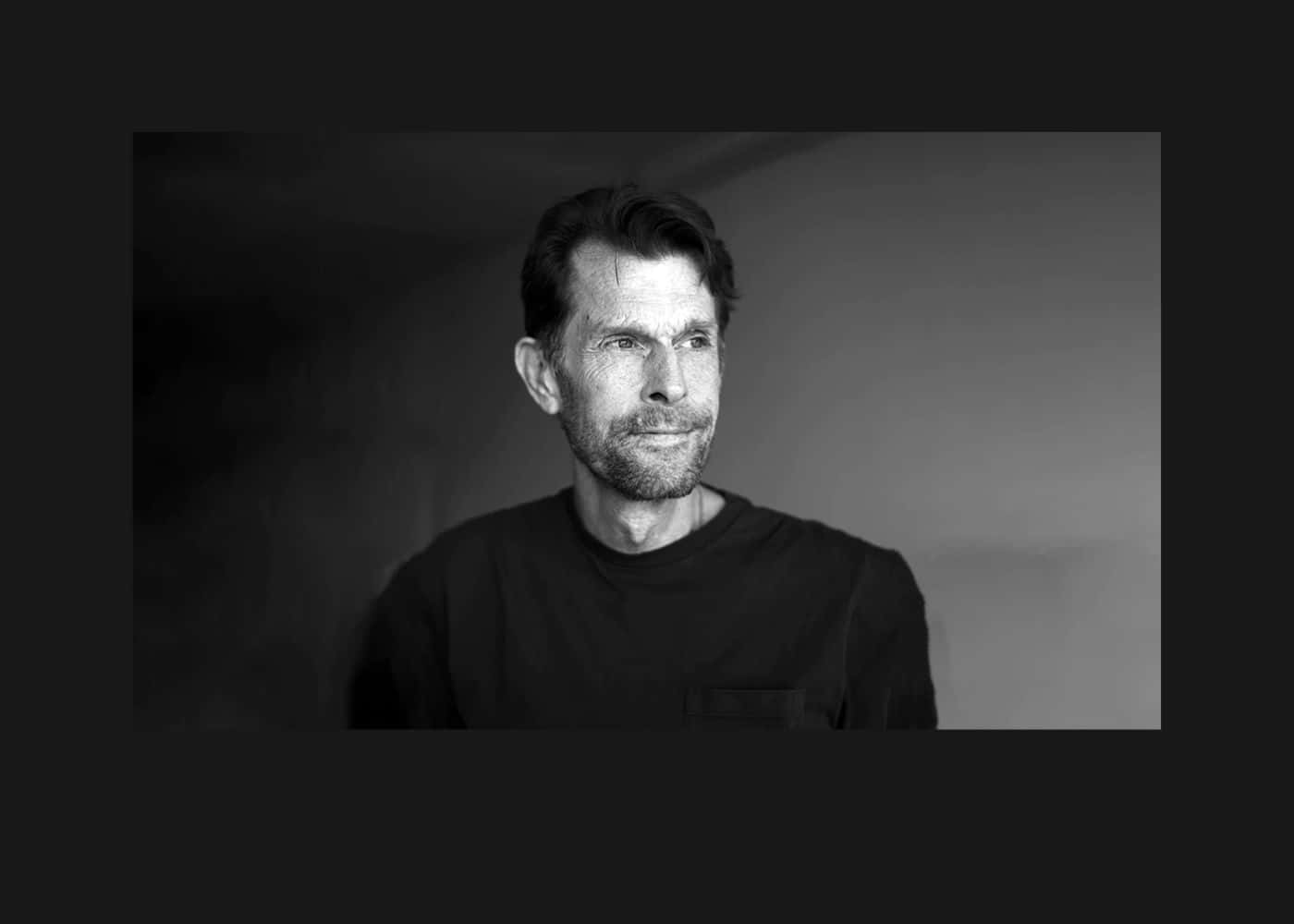 Kevin Conroy 桌布 壁紙 — 一幅黑白肖像，一名留鬍鬚的男子在漸變背景前若有所思地望向側面。