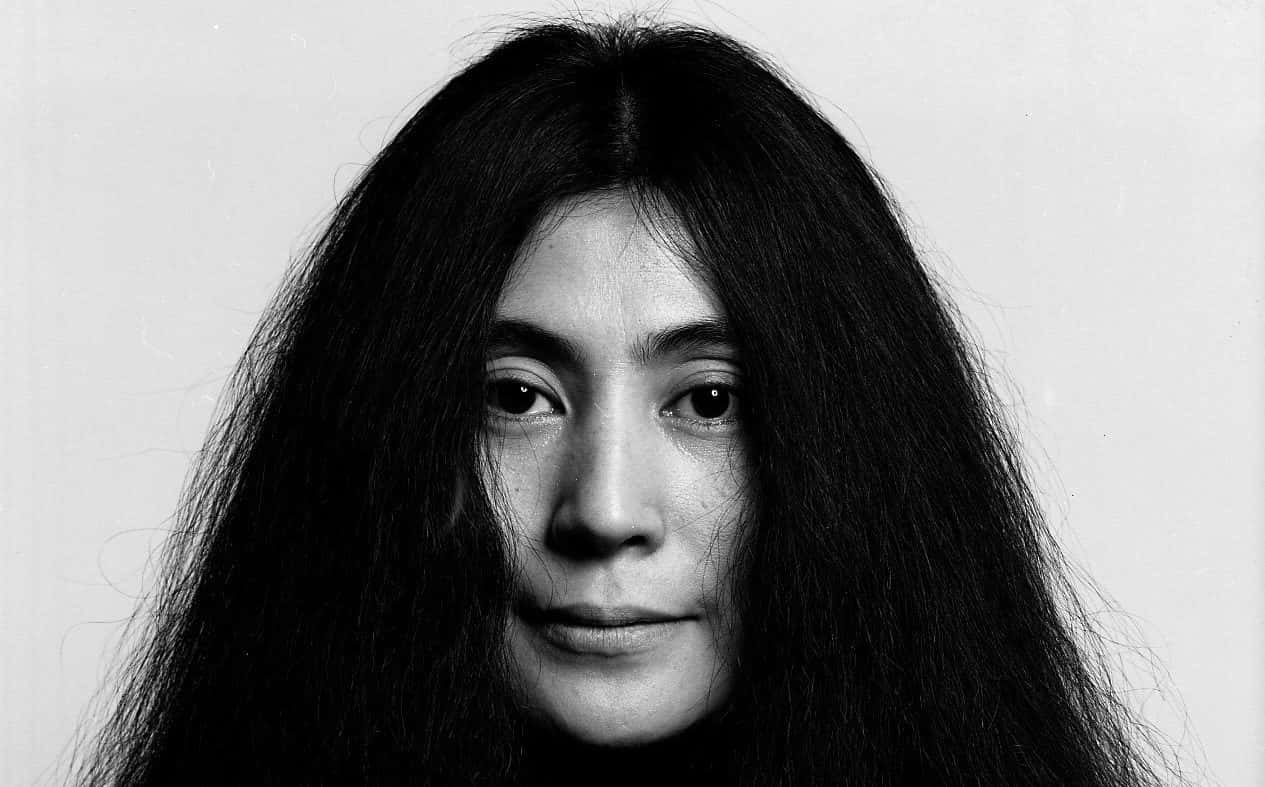 Monochrome 桌布 壁紙 — 一幅黑白肖像，一名長黑髮的女性在純色背景前直視鏡頭。