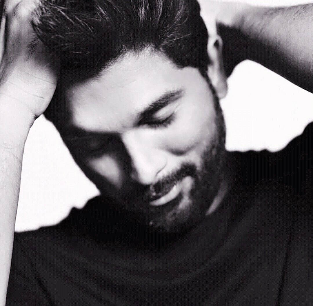 Allu Arjun 桌布 壁紙 — 一幅黑白肖像，一名鬍鬚男閉上雙眼，雙手放在腦後，散發著平靜自信。