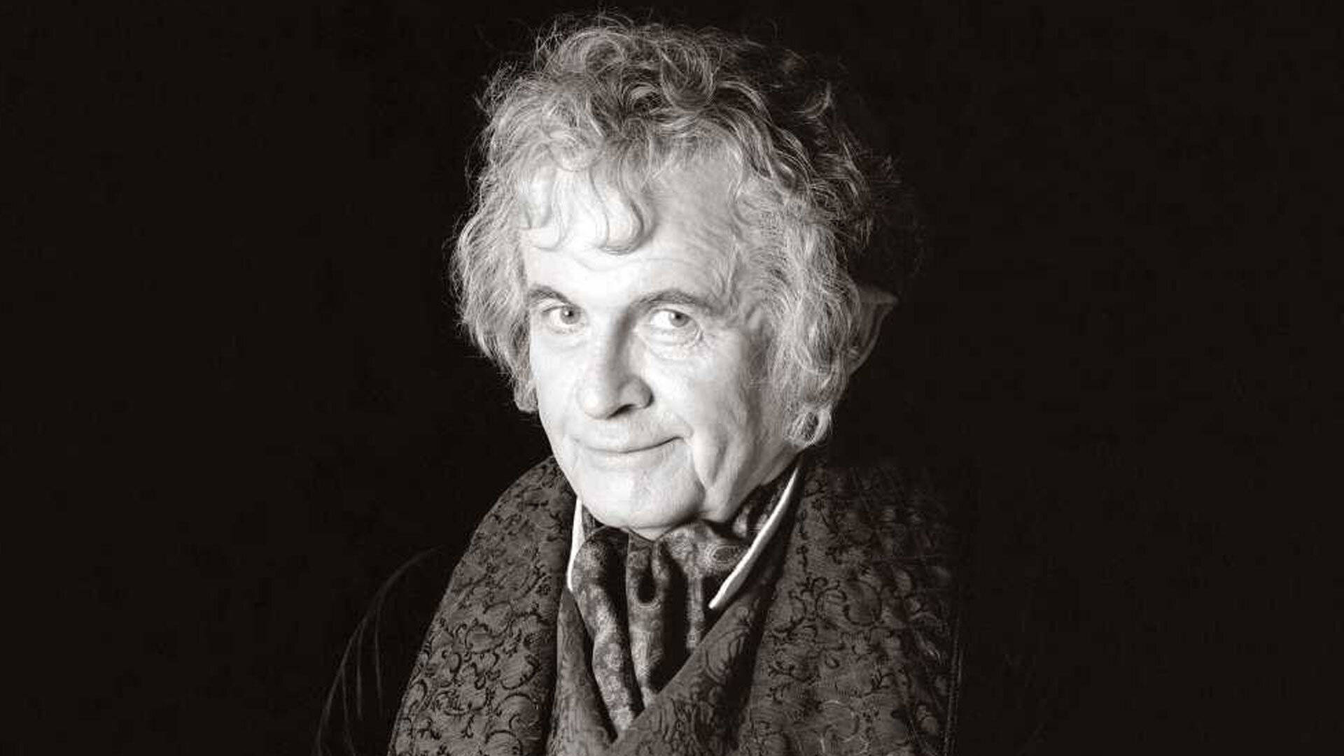 the hobbit 桌布 壁紙 — 一幅黑白肖像，拍攝一位長者女性，她擁有灰色捲髮，戴著圖案圍巾，背景深色。