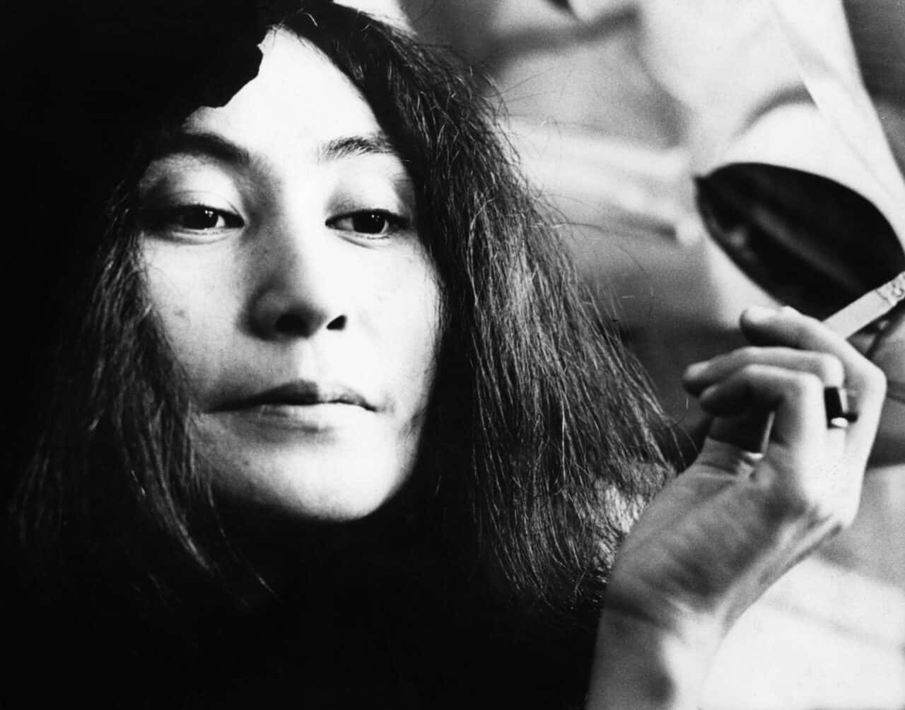 復古 桌布 壁紙 — 一幅黑白肖像照，一名深色頭髮的女性將香煙放在唇邊，眼神若有所思。