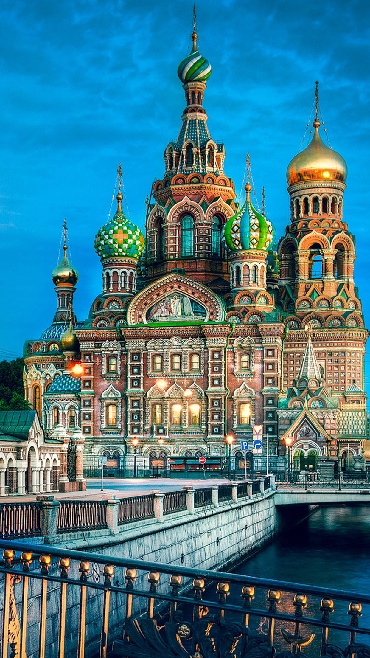 Russia 桌布 壁紙 — 一座令人驚嘆的俄羅斯東正教教堂，擁有色彩繽紛的洋蔥形圓頂和金色尖塔，在深藍色的暮色天空中閃耀。