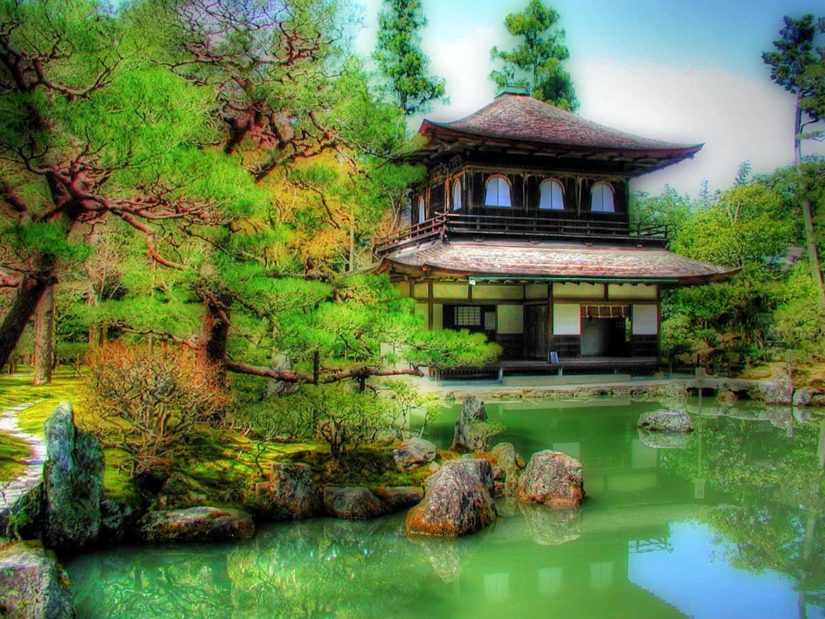 Japan Landscape 桌布 壁紙 — 一座傳統日本亭閣寧靜地坐落在長滿青苔的池塘旁，周圍環繞著鮮綠的樹木和岩石，在明亮的天空下。