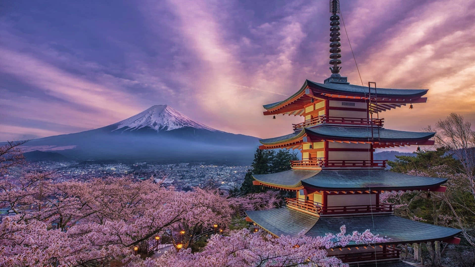 富士山 桌布 壁紙 — 一座傳統日本寶塔矗立在盛開的櫻花之中，背後是白雪覆蓋的富士山，在充滿活力的暮色天空下升起。