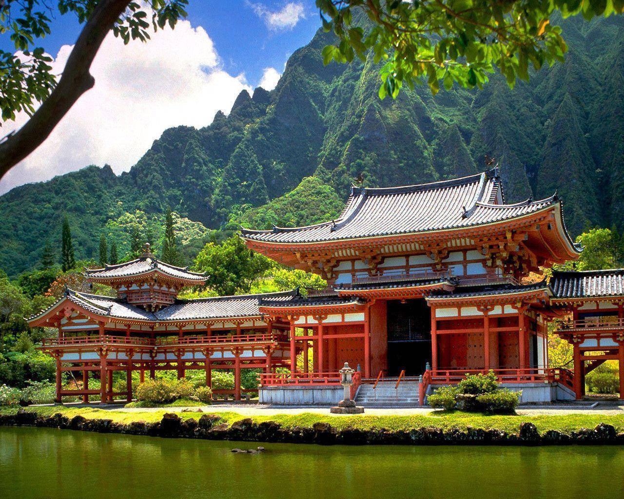 池塘旁的紅色木造寺廟，背景有翠綠山巒 — 高清自然 壁紙