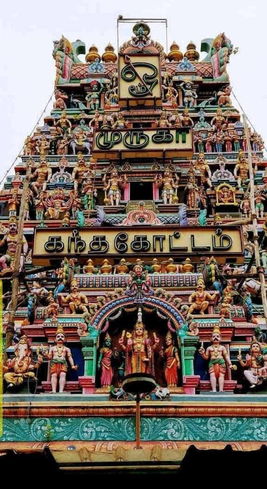 Hindu Temple 桌布 壁紙 — 一座充滿活力、細節精緻的印度教寺廟塔門，在陰天之下飾有色彩繽紛的雕像和泰米爾文字。