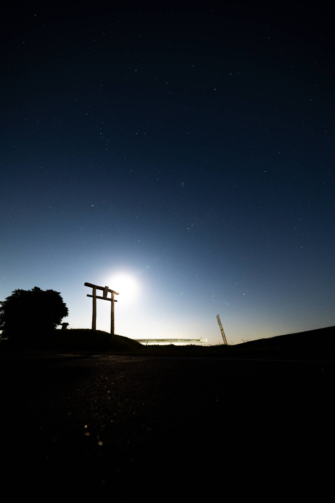 剪影的鳥居在繁星點點的夜空下，伴隨著一輪明亮的月亮。 — iPad mini 動態圖片 壁紙