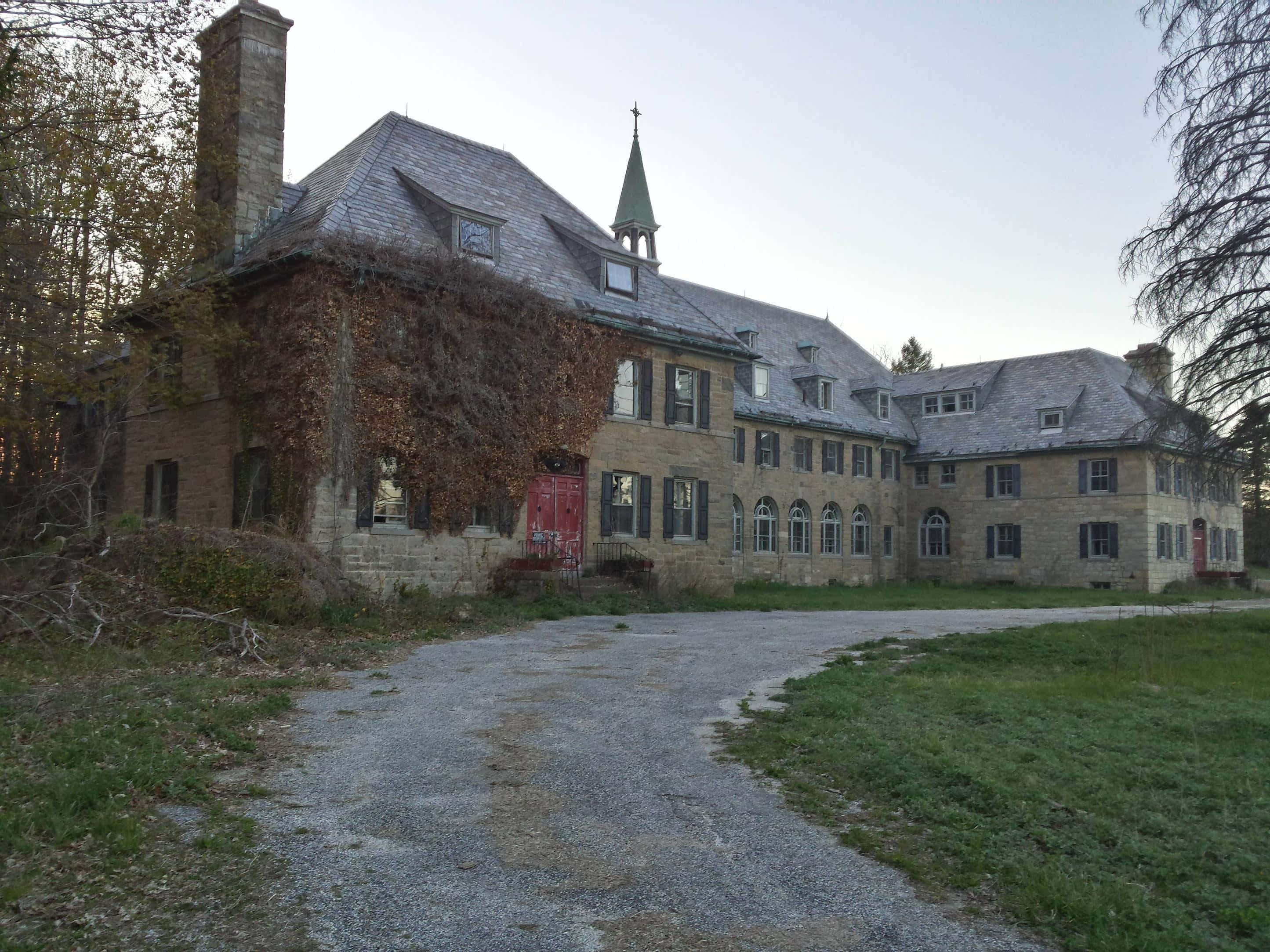 Abandoned 桌布 壁紙 — 一座古老的石砌豪宅，牆壁爬滿常春藤，紅色大門，被遺棄在寧靜的秋日森林中。