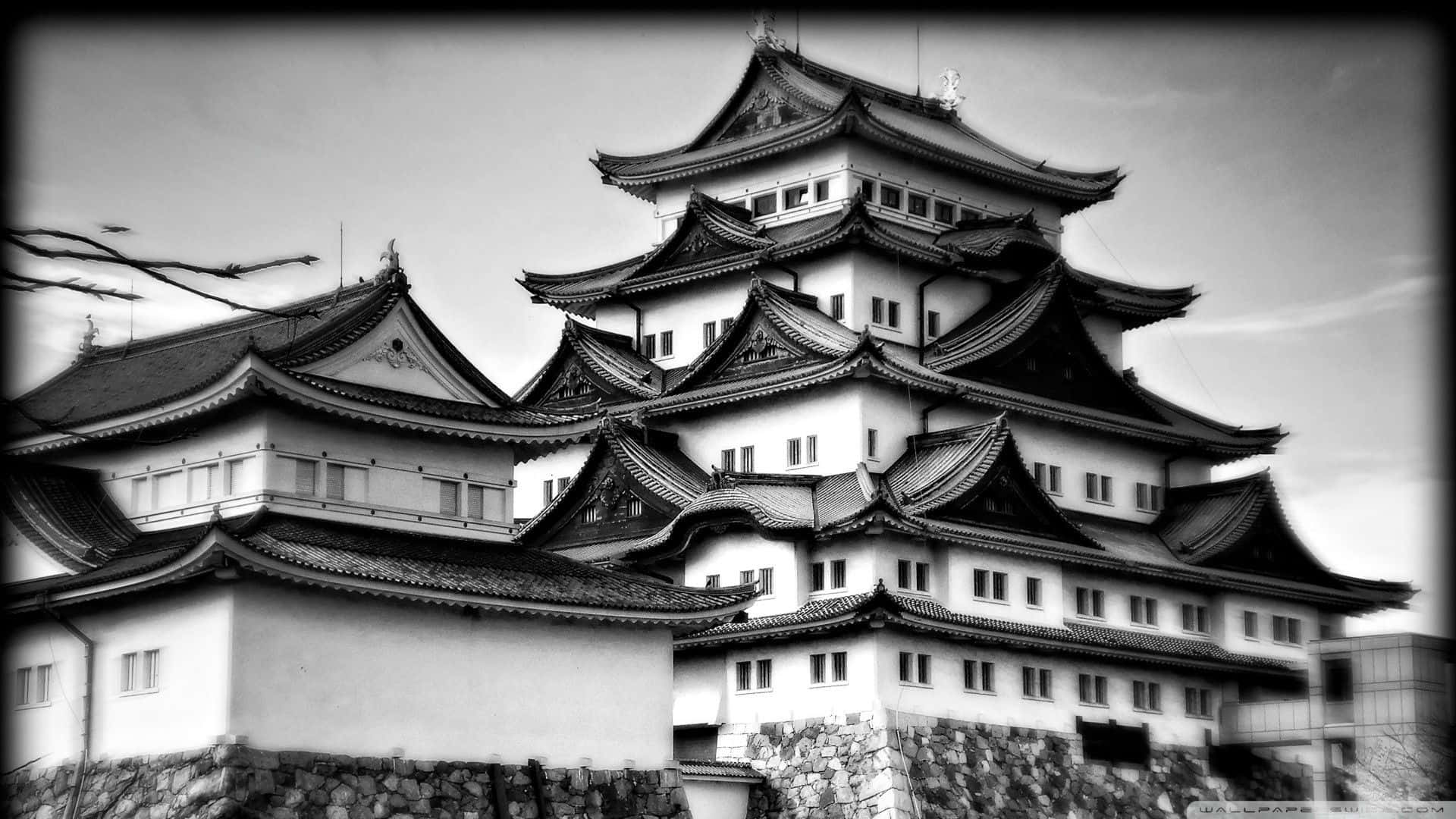 日本黑白 桌布 壁紙 — 一座多層日本城堡的醒目黑白景觀，擁有流線型彎曲屋頂和石頭地基。