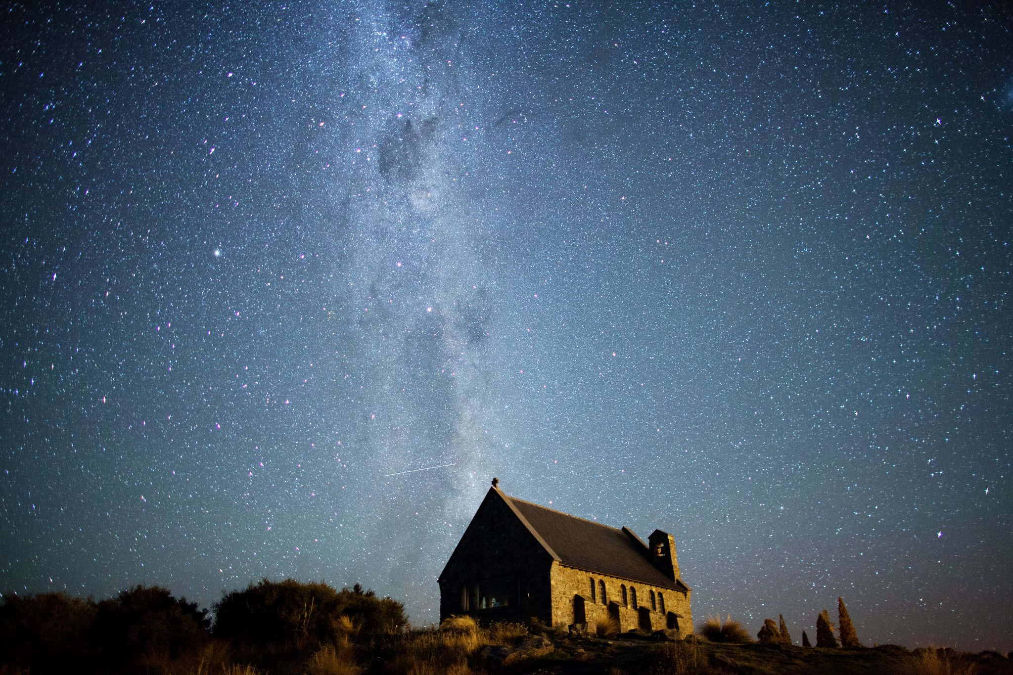 Dark Sky 桌布 壁紙 — 一座孤獨的石頭教堂矗立在令人嘆為觀止的星空下，銀河在頭頂閃耀。