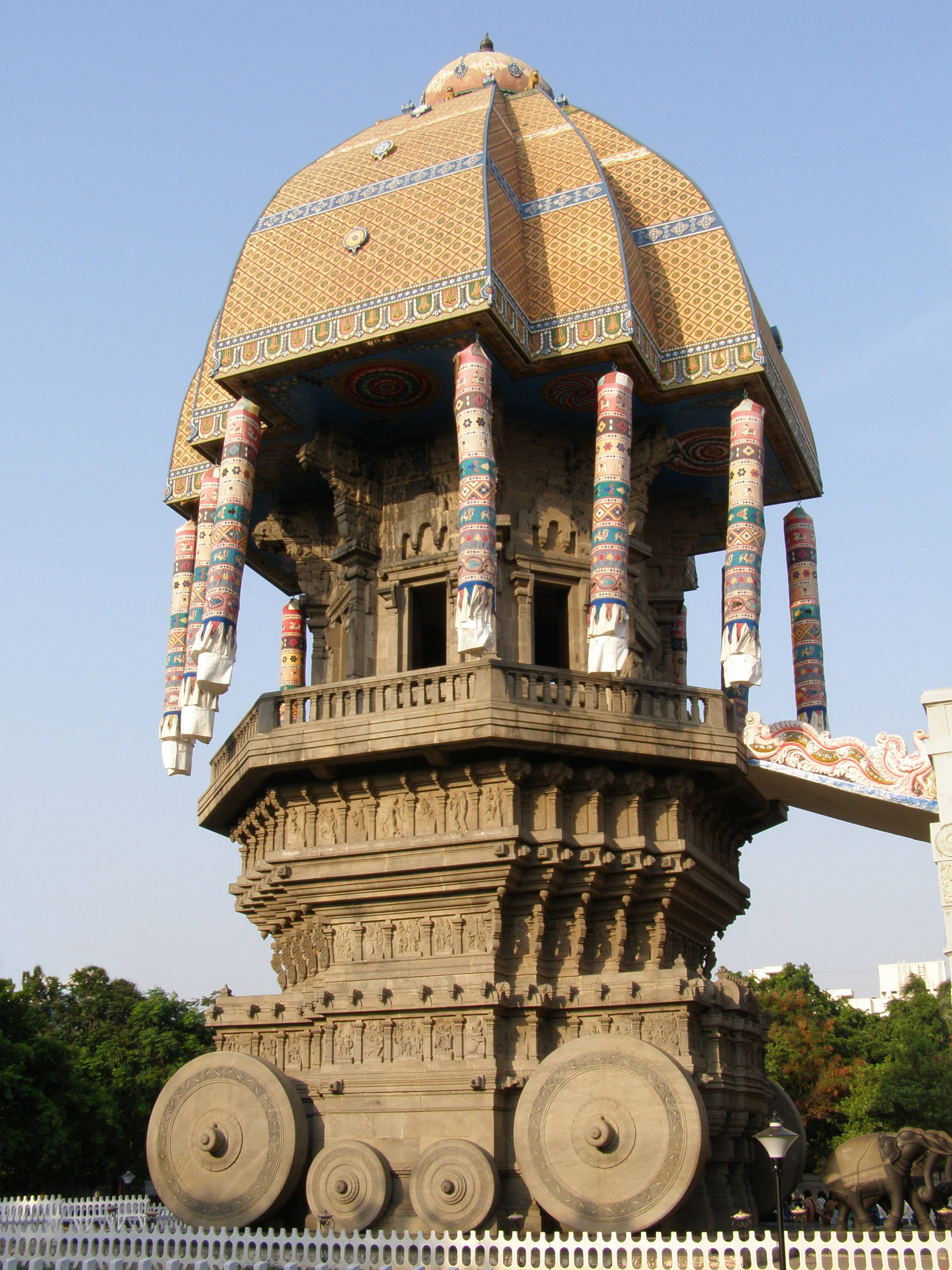 Chennai 桌布 壁紙 — 一座宏偉、雕刻精緻的石造寺廟塔，帶有彩色瓷磚圓頂和大象圖案，矗立在晴朗的藍天下。