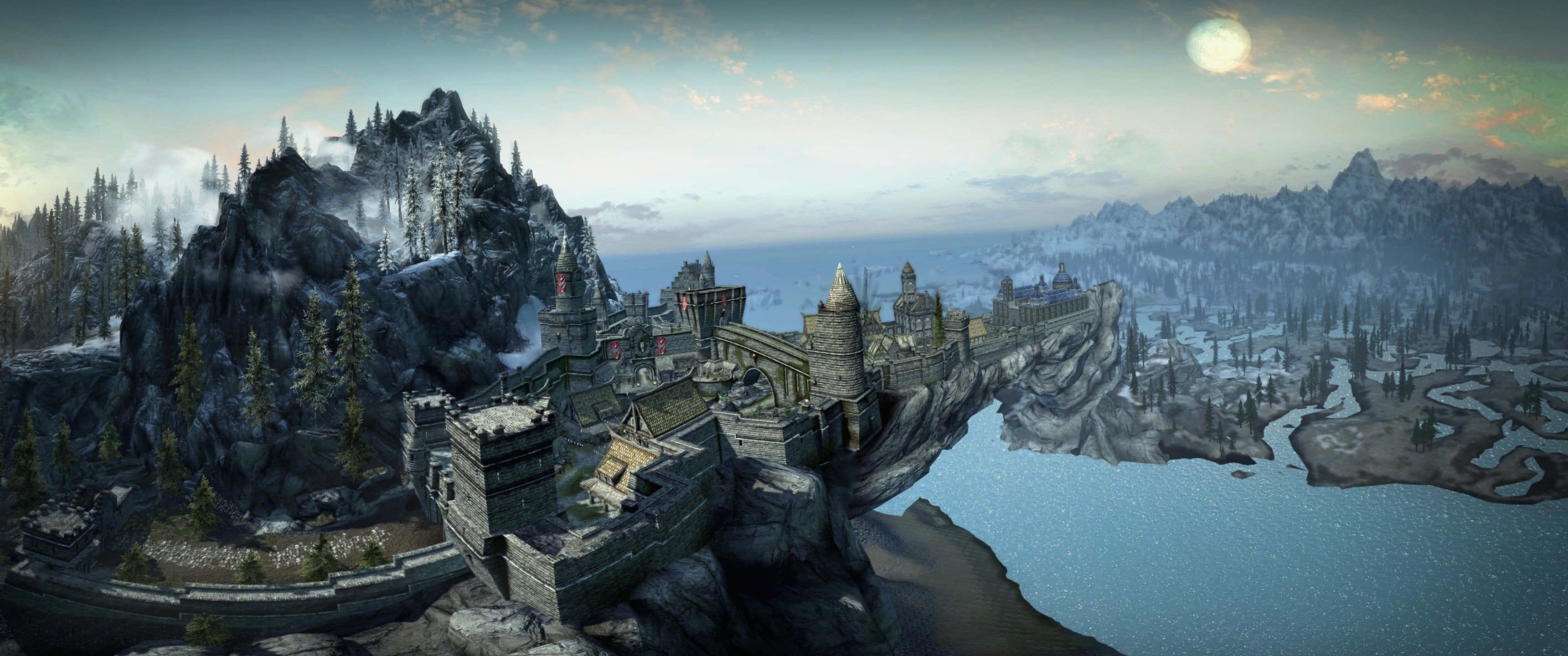 Skyrim Solitude 桌布 壁紙 — 一座宏偉的中世紀城堡坐落在白雪皚皚的山崖上，俯瞰著蒼白月光下結冰的湖泊。