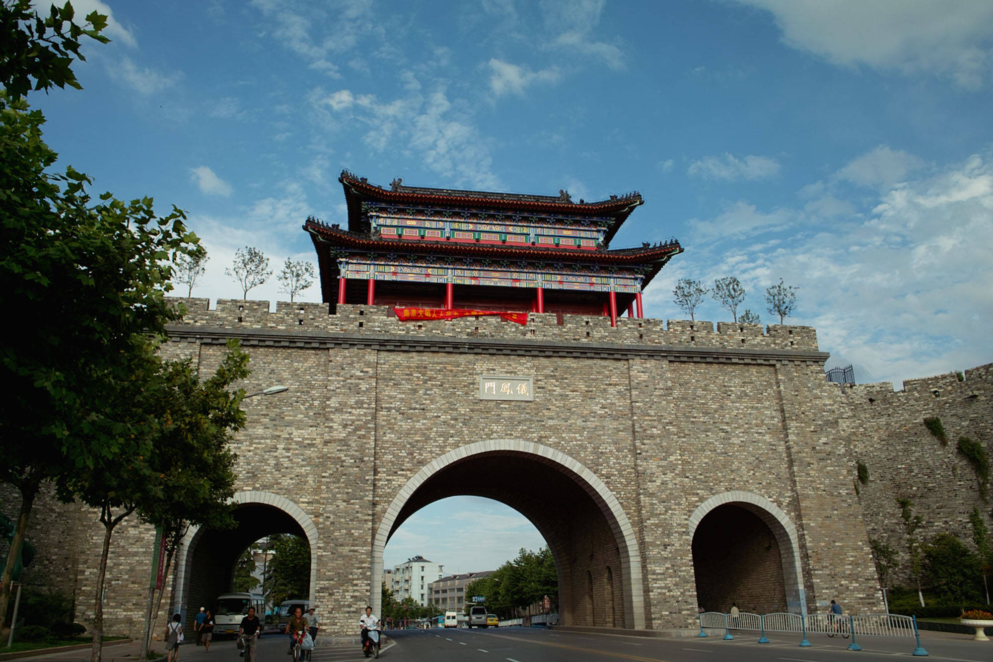 Nanjing 桌布 壁紙 — 一座宏偉的傳統中國城門，紅柱和瓦頂在藍天白雲下巍然聳立。