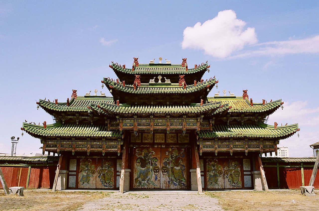 Mongolia 桌布 壁紙 — 一座宏偉的傳統中國寺廟，擁有層疊的綠色屋頂和華麗的紅色裝飾，在明亮的藍天下。
