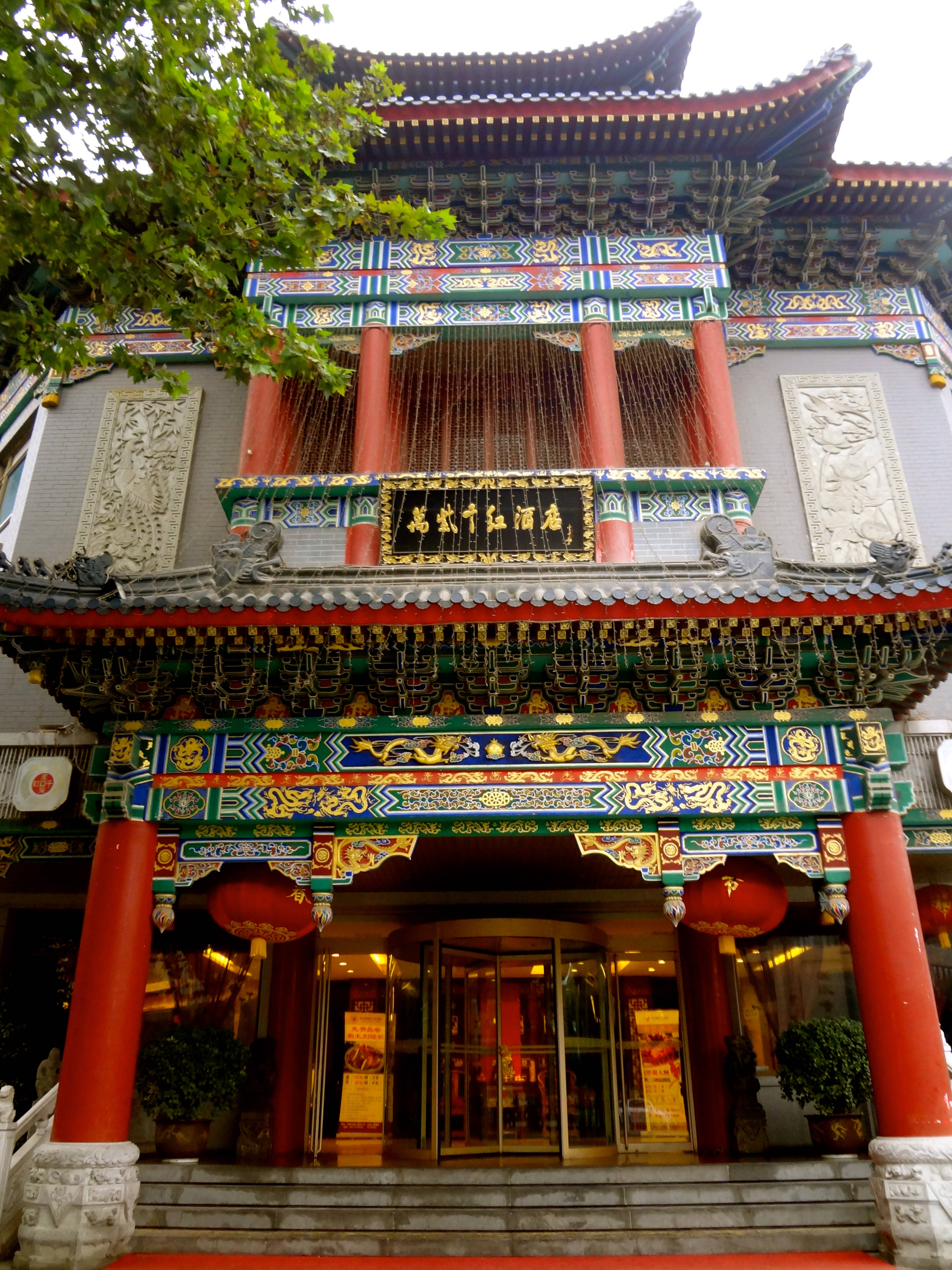 Xian 桌布 壁紙 — 一座宏偉的傳統中式建築，擁有紅色柱子、華麗屋頂和懸掛的燈籠，在明亮的天空下。