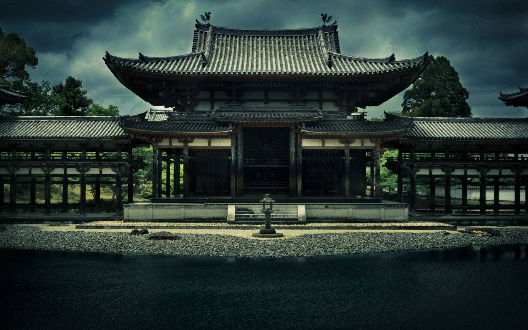 鳳凰 桌布 壁紙 — 一座宏偉的傳統日本寺廟，擁有寬闊的瓦片屋頂，在陰沉的暴風雨天空下莊嚴地矗立。