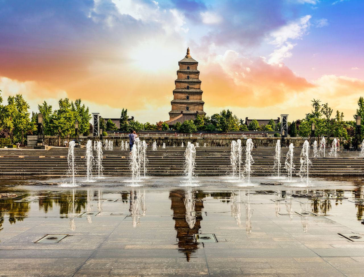 Xian 桌布 壁紙 — 一座宏偉的古塔矗立在層疊噴泉之後，在夕陽下映照在濕石上。