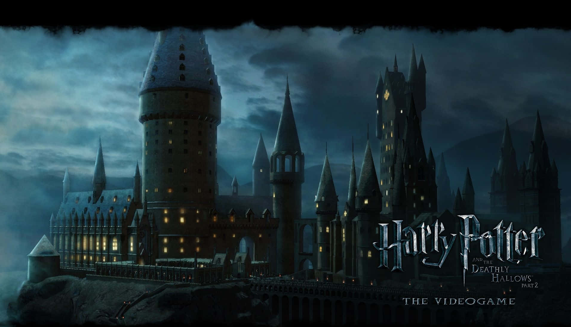 Hogwarts Castle 桌布 壁紙 — 一座宏偉的哥德式城堡，擁有積雪的塔樓和發光的窗戶，矗立在暴風雨的黃昏天空下。