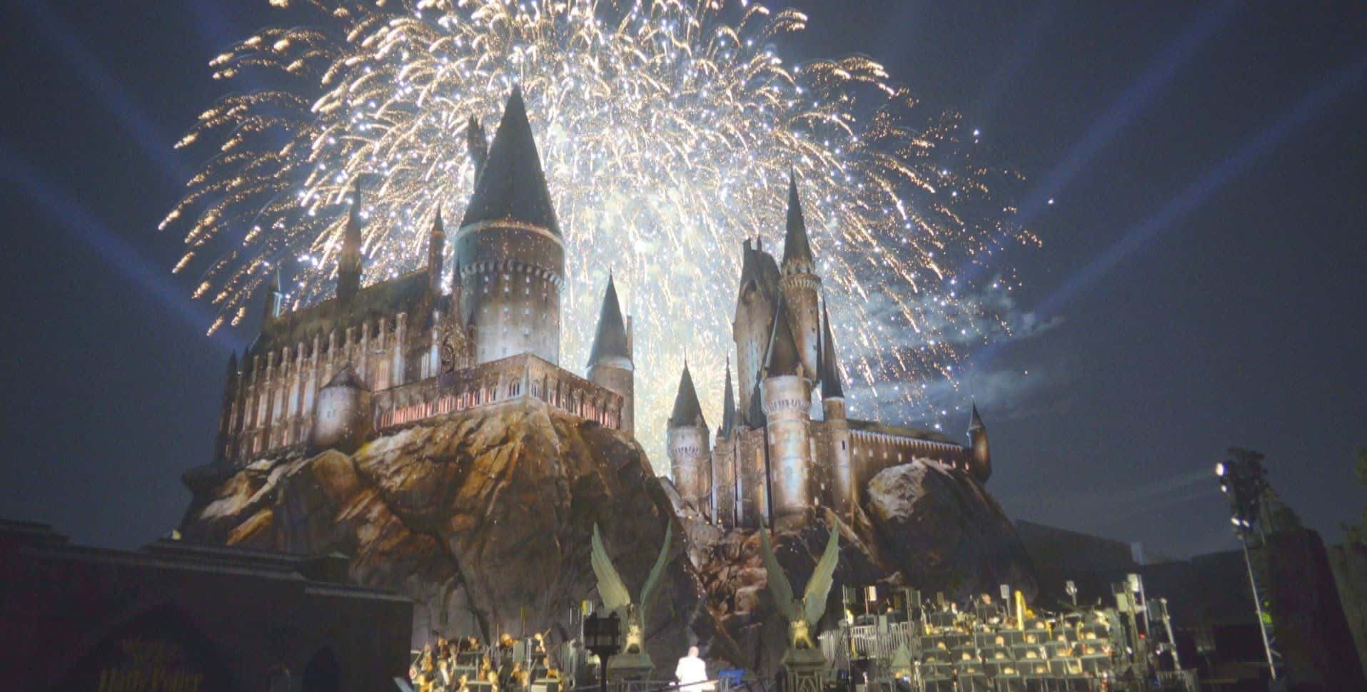 Hogsmeade 桌布 壁紙 — 一座宏偉的城堡，尖塔聳立，在漆黑的夜空中綻放出耀眼的煙火。