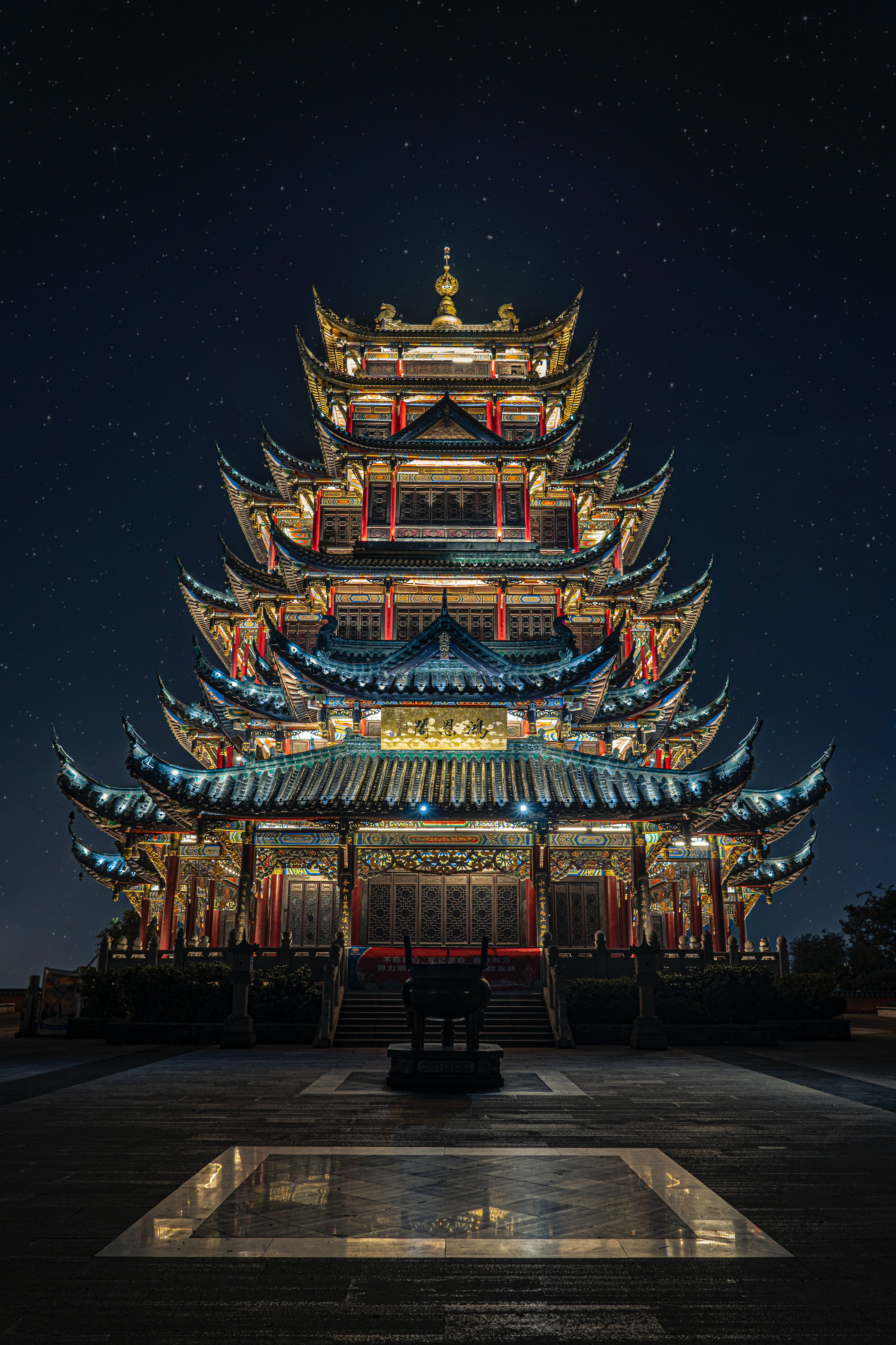 Super 桌布 壁紙 — 一座宏偉的多層傳統寶塔在星空下閃耀，前景有倒影池。