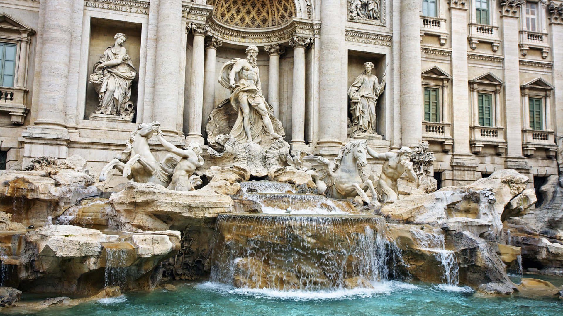 Rome 桌布 壁紙 — 一座宏偉的巴洛克式噴泉，擁有大理石雕像和層疊水流，位於古典石建築立面之下。