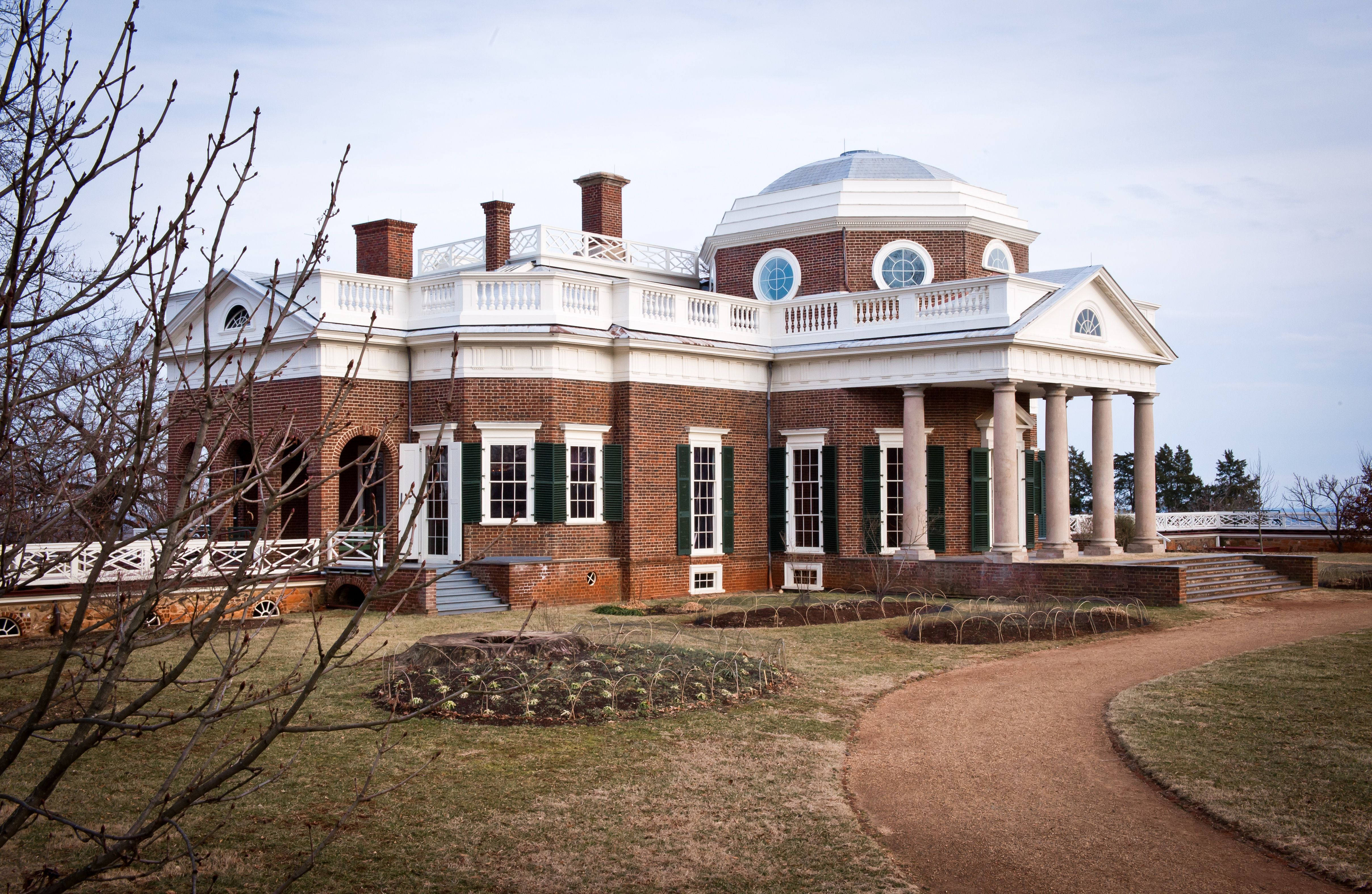 Virginia 桌布 壁紙 — 一座宏偉的新古典主義磚砌豪宅，擁有白色柱子和圓頂，矗立在蒼白的天空下，周圍是光禿禿的冬季樹木和蜿蜒的泥土小徑。
