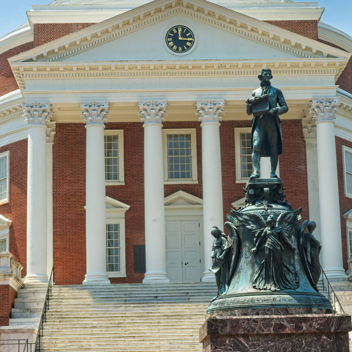 Virginia 桌布 壁紙 — 一座宏偉的新古典主義磚造建築，帶有白色柱子和入口上方的時鐘，前方的大理石基座上有一座銅像。