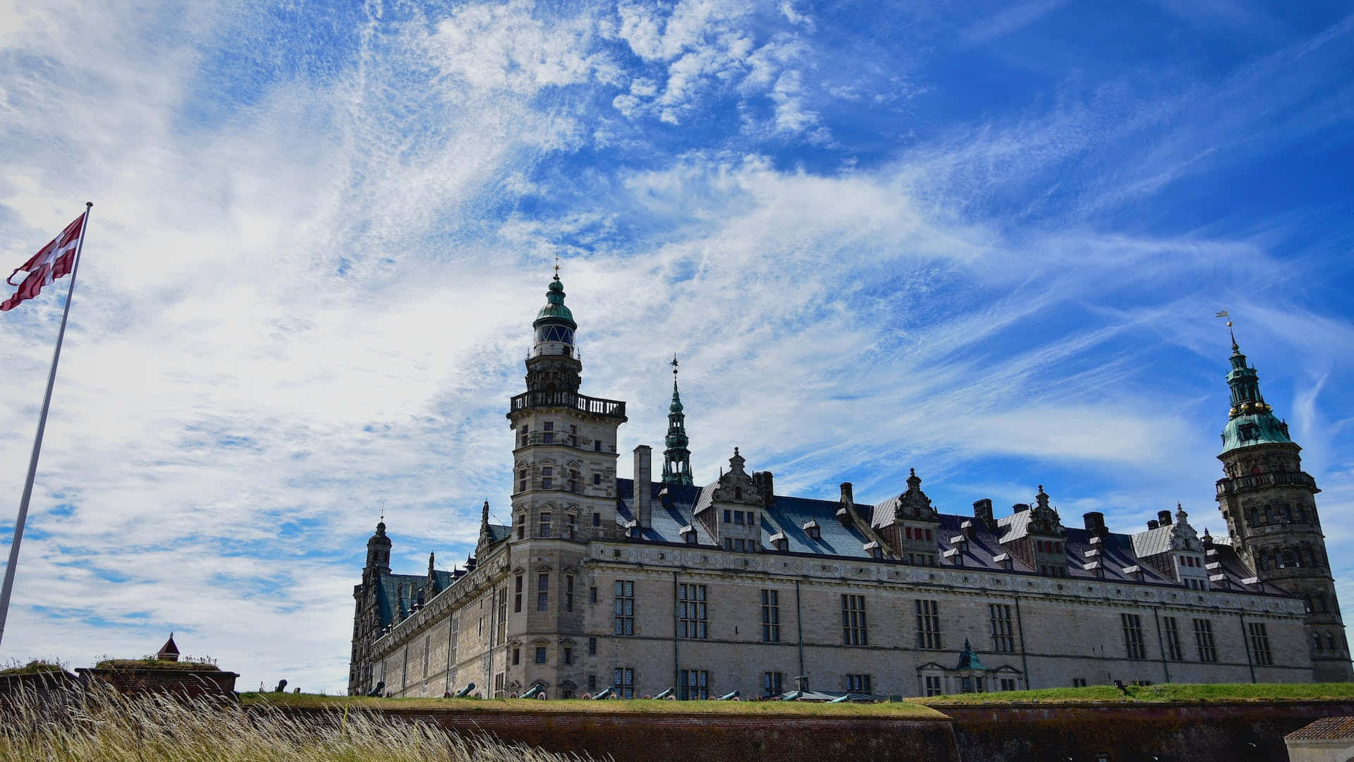 Denmark 桌布 壁紙 — 一座宏偉的歷史城堡，擁有華麗的塔樓，矗立在藍天白雲下。