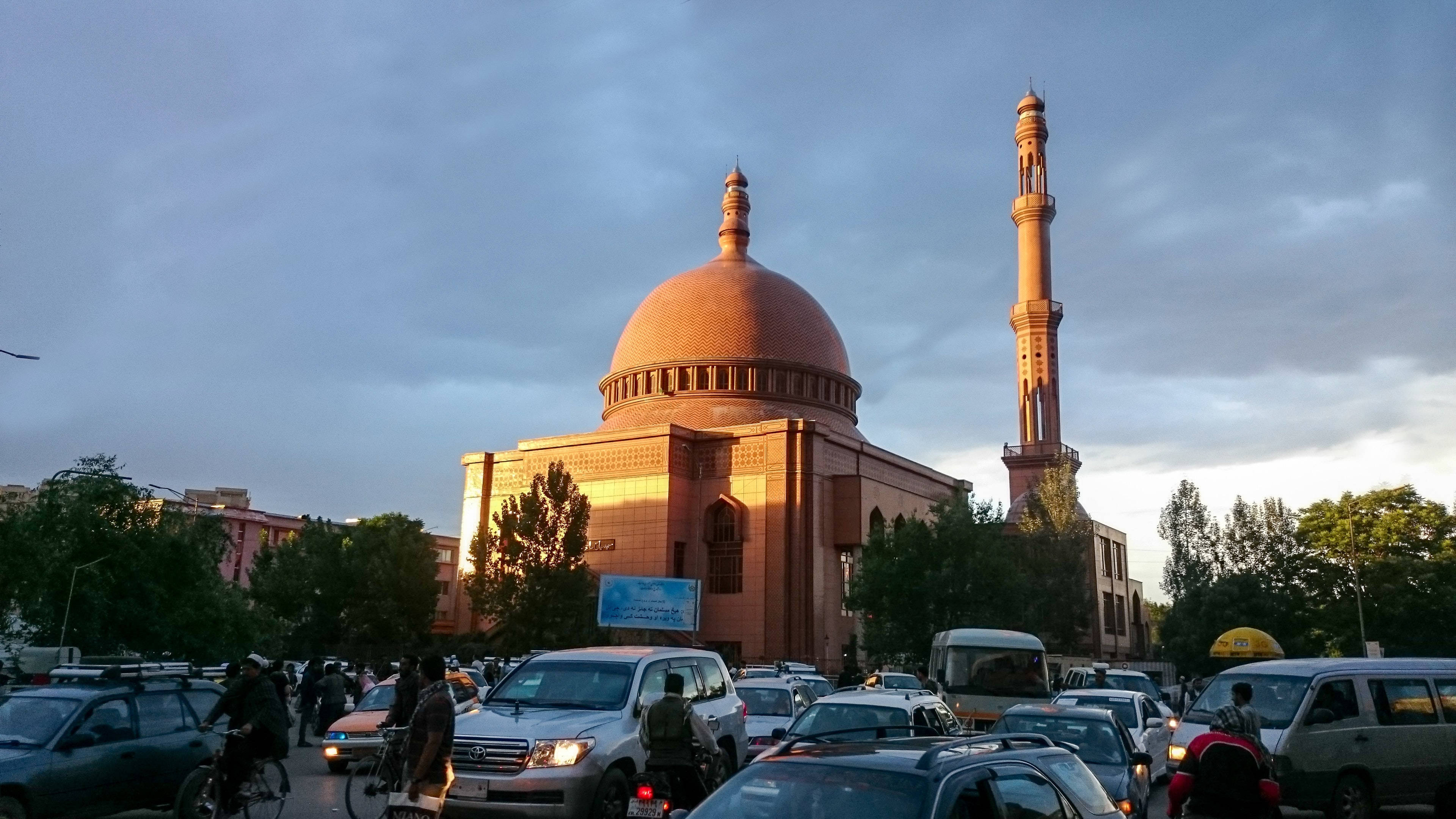 Kabul 桌布 壁紙 — 一座宏偉的清真寺，擁有銅製圓頂和高聳的宣禮塔，在黃金時段矗立於繁忙的交通中。