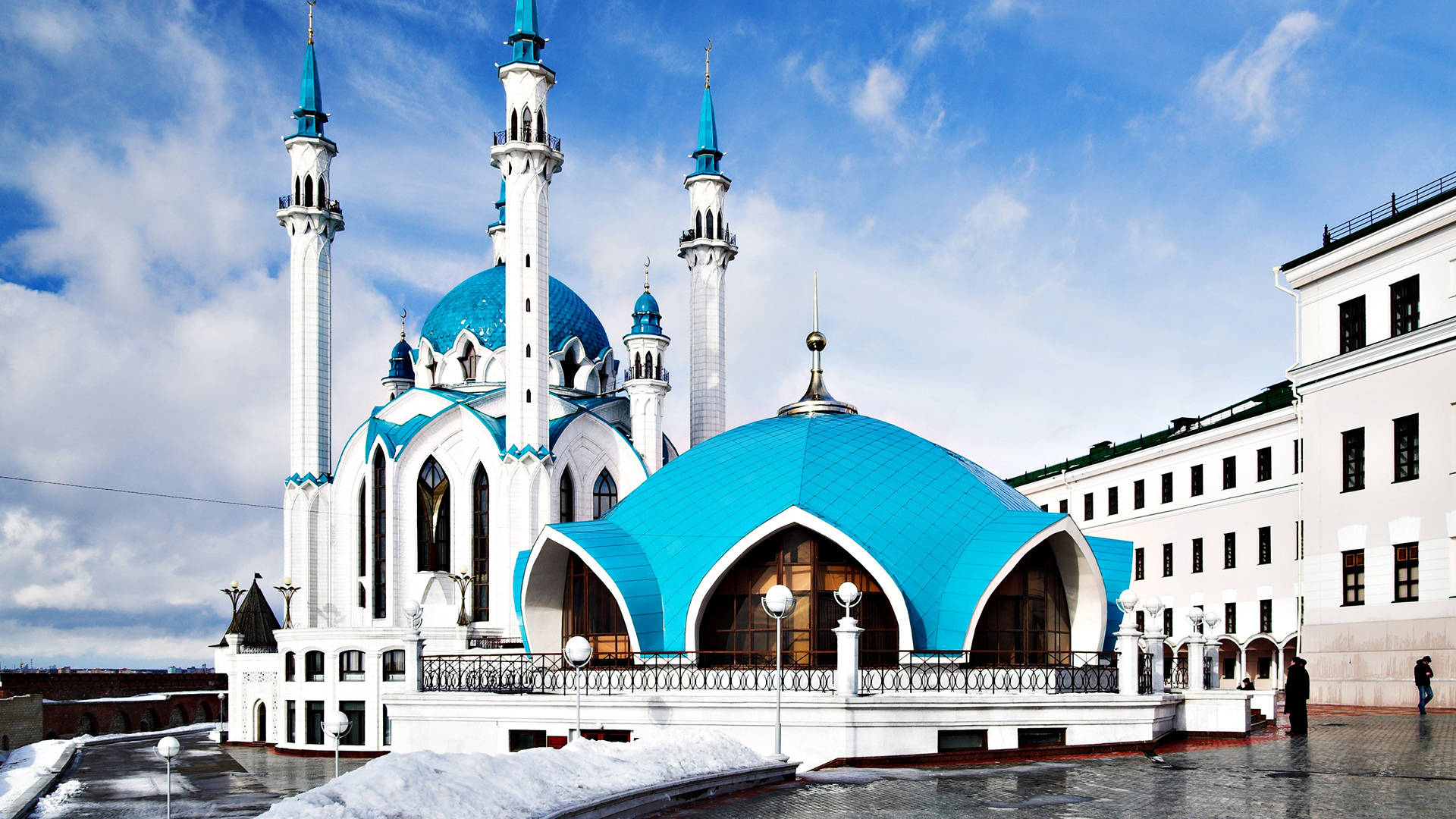 Kazan 桌布 壁紙 — 一座宏偉的清真寺，擁有鮮豔的藍色圓頂和白色宣禮塔，矗立在明亮的藍天下，天空中有散落的雲朵，地面積雪。