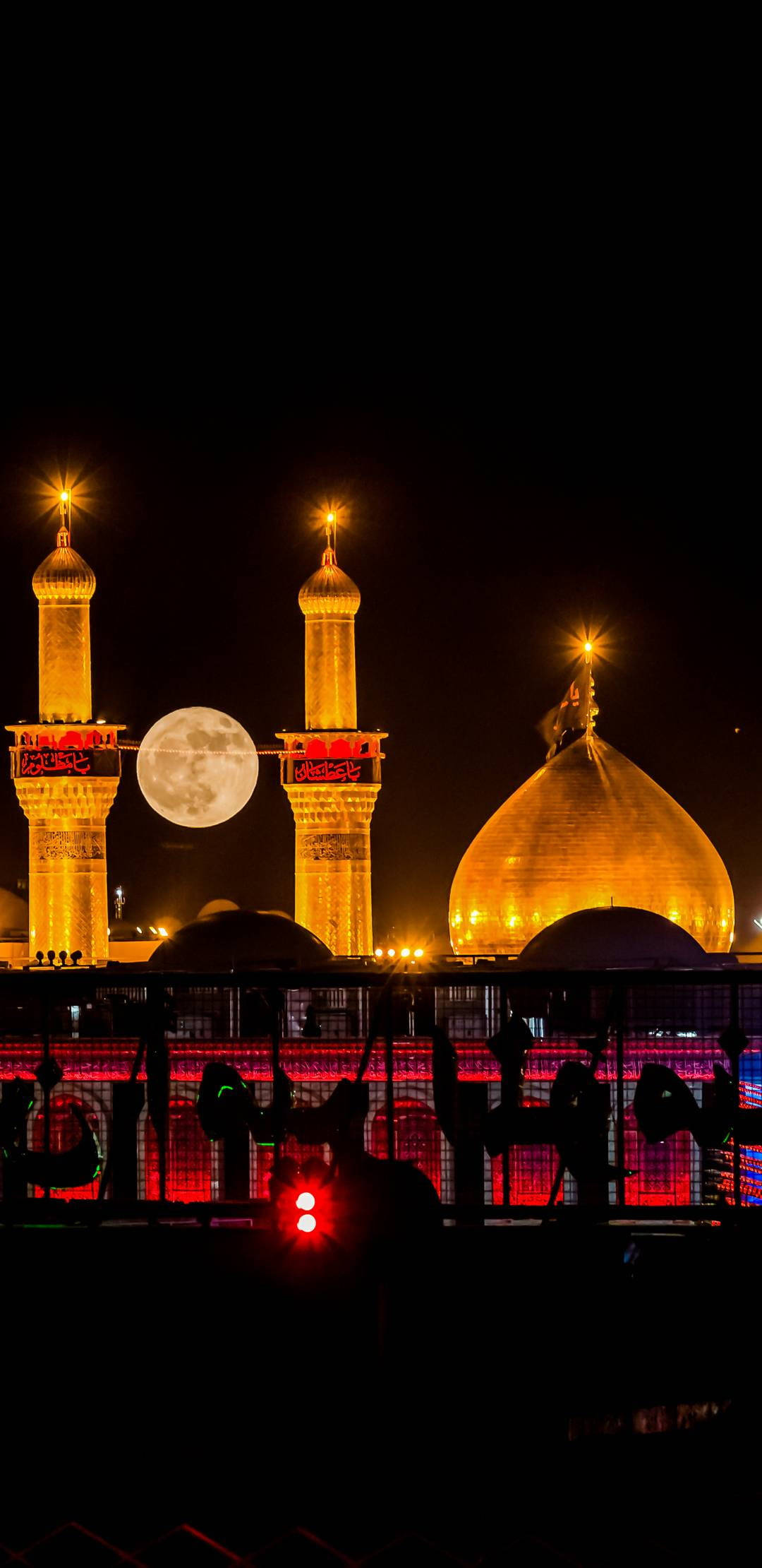 Madina Full HD 桌布 壁紙 — 一座宏偉的清真寺在夜晚被照亮，金色圓頂和宣禮塔在滿月下閃耀。