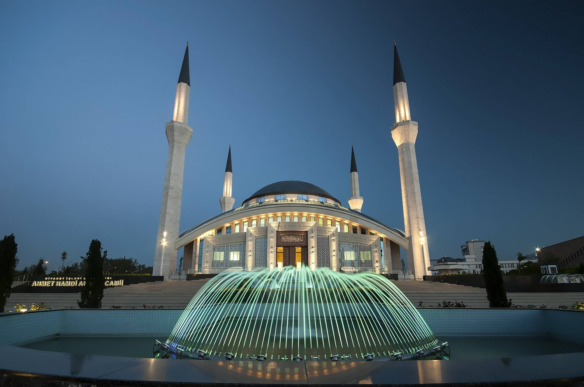 Ankara 桌布 壁紙 — 一座宏偉的燈光清真寺，擁有高聳的宣禮塔和前方在黃昏時閃耀的噴泉。