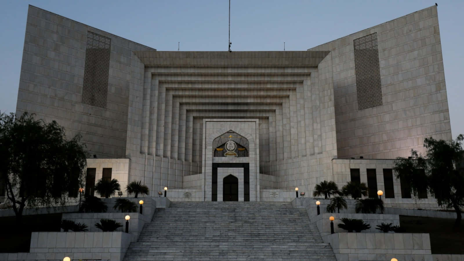 Pakistan 桌布 壁紙 — 一座宏偉的現代政府建築，擁有分層石砌建築和黃昏時亮起的台階。