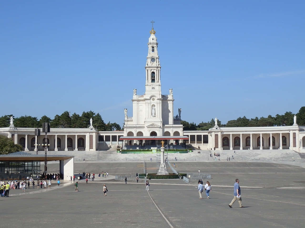 Portugal 桌布 壁紙 — 一座宏偉的白色大教堂，擁有高聳的鐘樓，矗立在清澈的藍天下，周圍是寬闊的廣場，散落著遊客。
