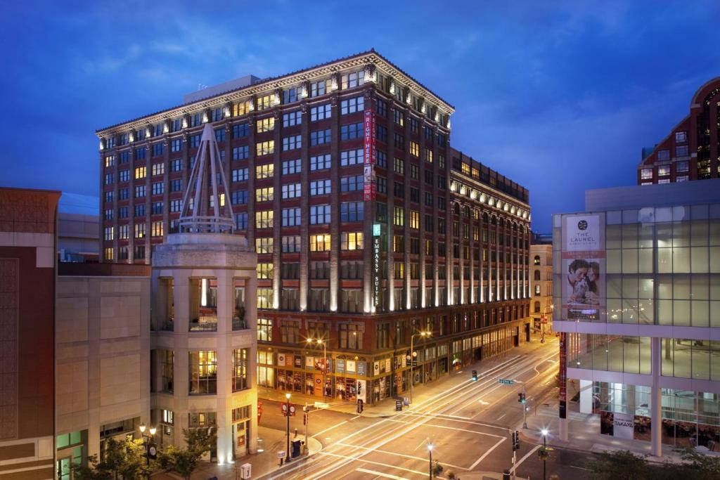 United States 桌布 壁紙 — 一座宏偉的磚砌建築，窗戶閃爍著光芒，矗立在城市街角，背景是深藍色的暮色天空。
