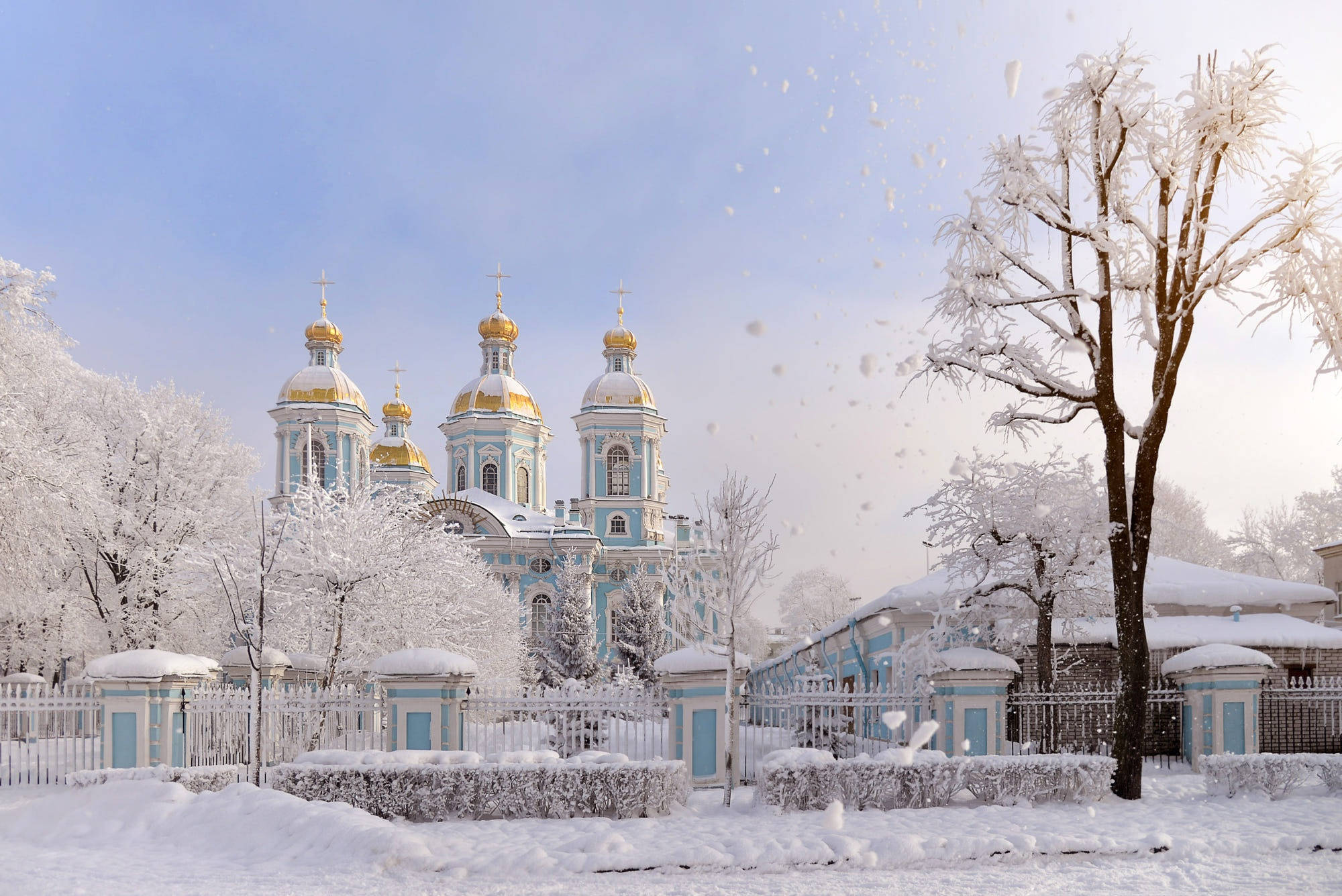 Russia 桌布 壁紙 — 一座宏偉的藍金色圓頂大教堂在飄雪中靜靜矗立，周圍是結霜的樹木和白色圍欄，冬日景象。