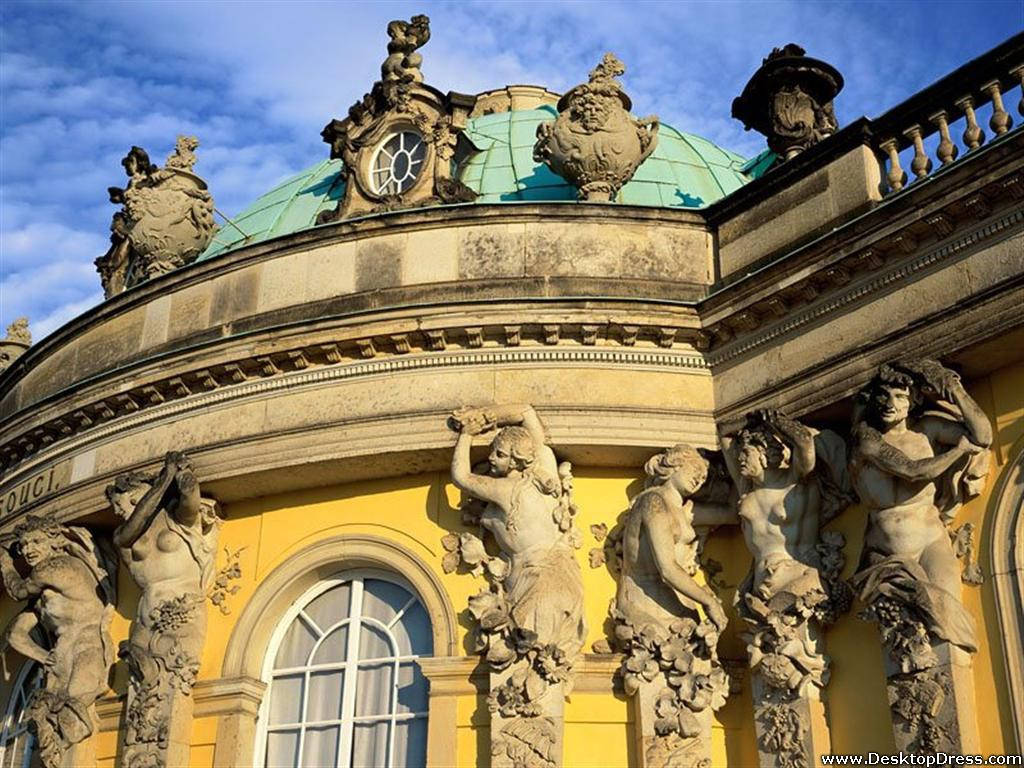 Potsdam 桌布 壁紙 — 一座宏偉的黃色巴洛克建築，帶有華麗的石雕和綠色銅圓頂，在藍天下。