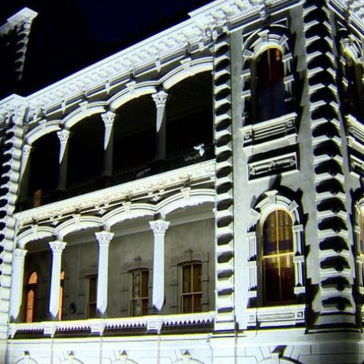 Architecture 桌布 壁紙 — 一座宏偉華麗的建築物外牆在夜間被戲劇性的燈光照亮，在其複雜的建築細節上投下深深的陰影。