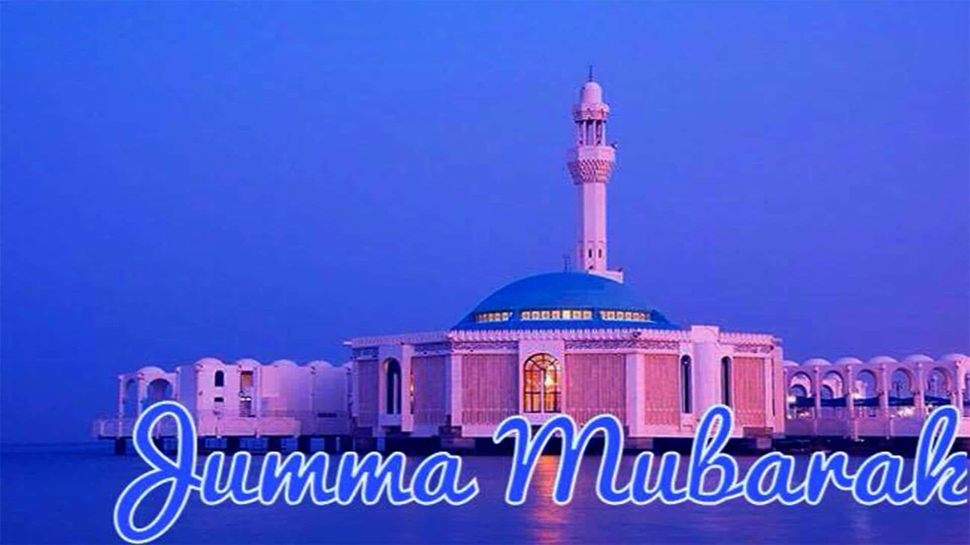 Jumma Mubarak 桌布 壁紙 — 一座寧靜的清真寺，擁有藍色圓頂和宣禮塔，矗立在水面上，在暮色中於紫色天空下發光，並帶有'Jumma Mubarak'文字。