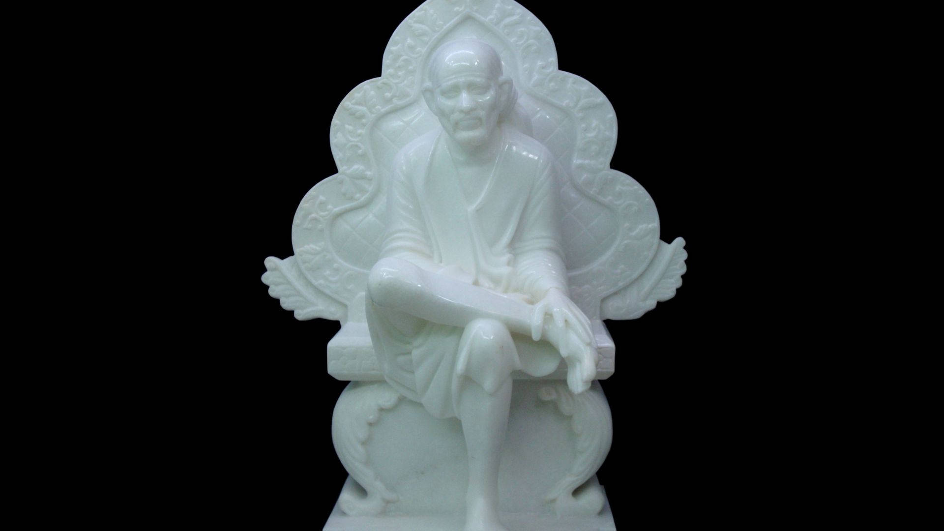 白色大理石雕像，描繪一位坐著的僧侶，坐在華麗的寶座上，背景為黑色。