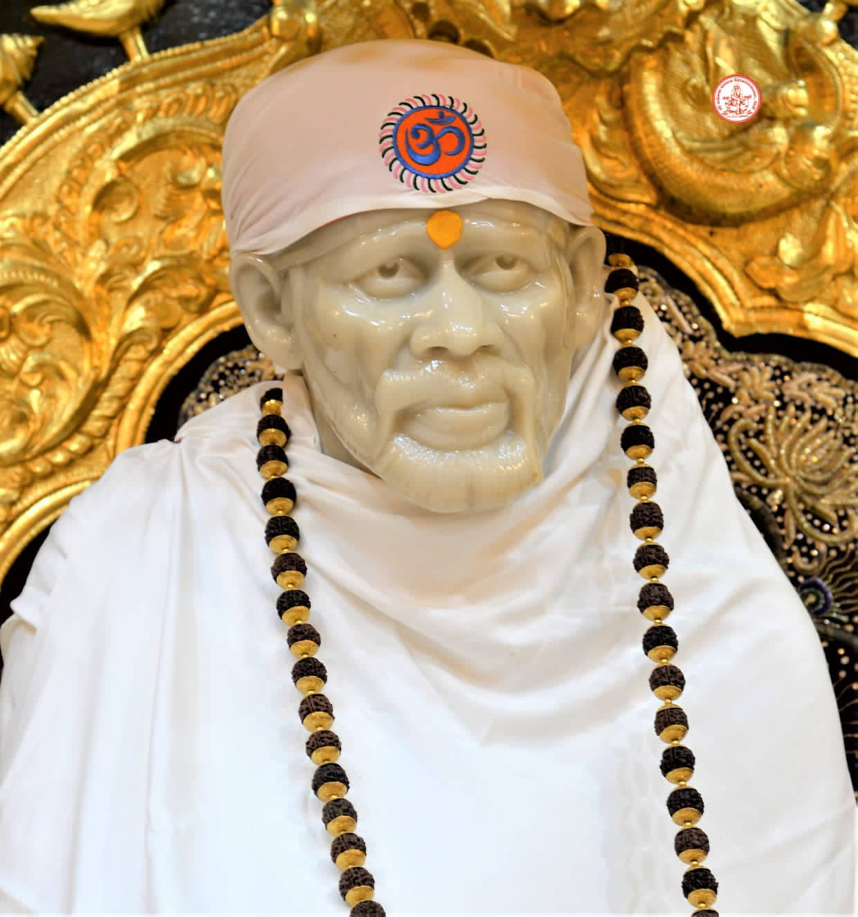 靈性導師雕像，帶有珠子和 Om 符號，置於金色寶座上 — Sai Baba 高畫質壁紙 壁紙