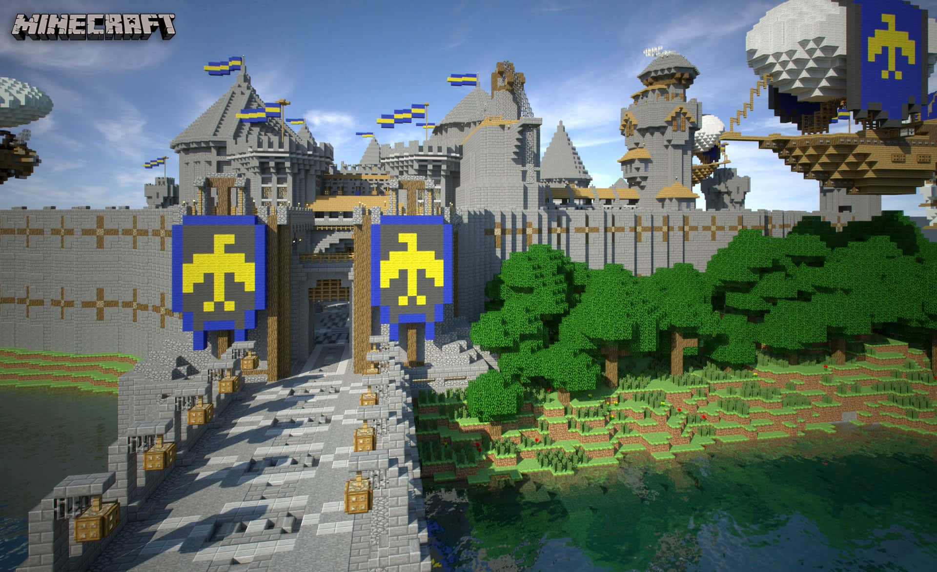 Minecraft Map 桌布 壁紙 — 一座巨大的Minecraft城堡，擁有灰色石塔和藍色旗幟，矗立在河邊，周圍綠樹成蔭，天空湛藍。