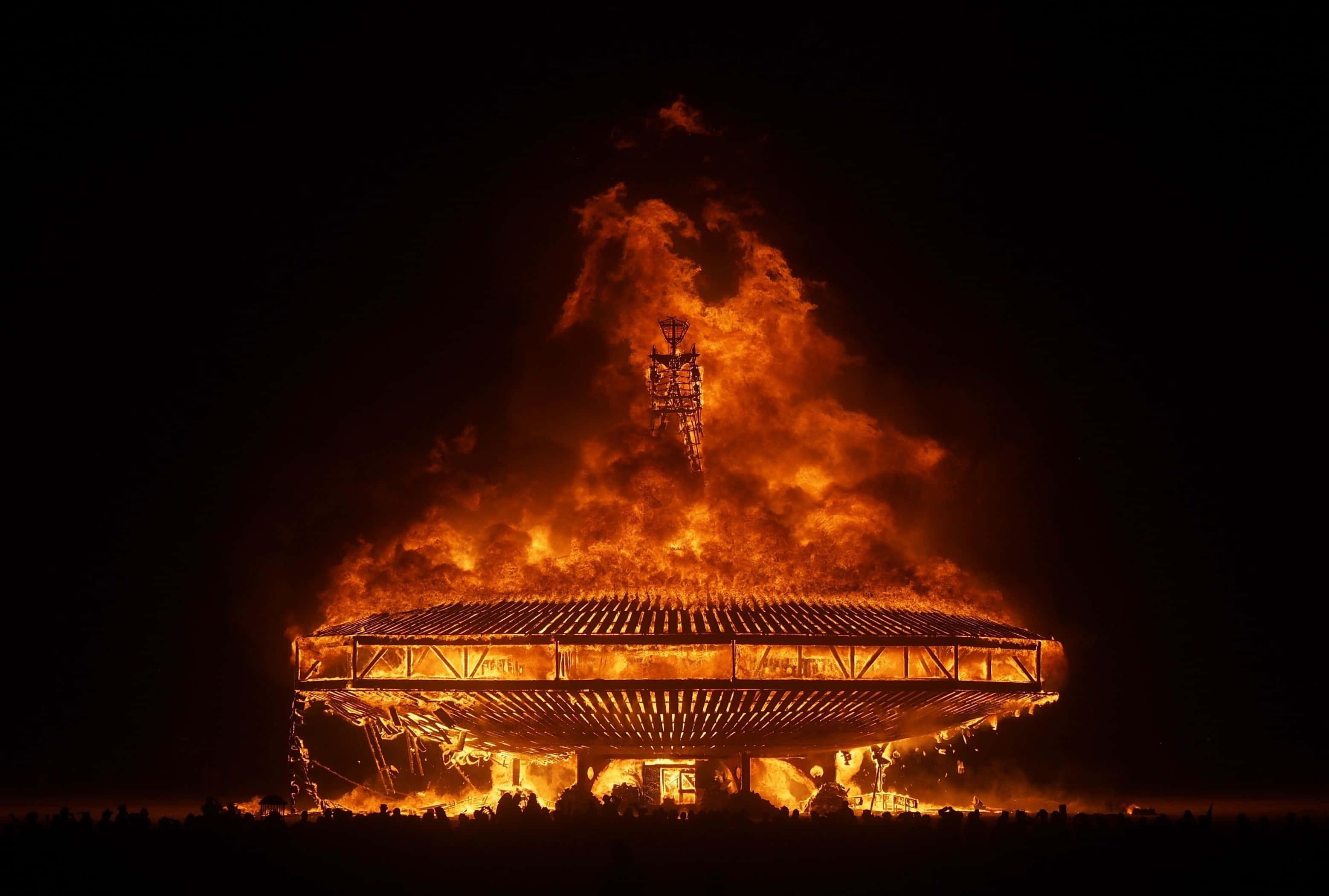 Burn 桌布 壁紙 — 一座巨大的建築物在夜間猛烈燃燒，火焰吞噬了屋頂和塔樓，映襯著黑色的天空。