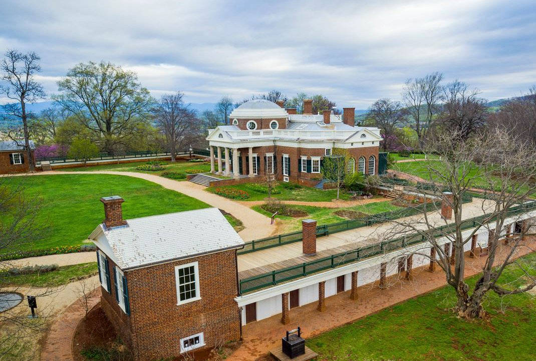Virginia 桌布 壁紙 — 一座帶有圓頂和柱子的宏偉新古典主義豪宅坐落在山頂上，周圍環繞著修剪整齊的草坪和萌芽的樹木，天空多雲。
