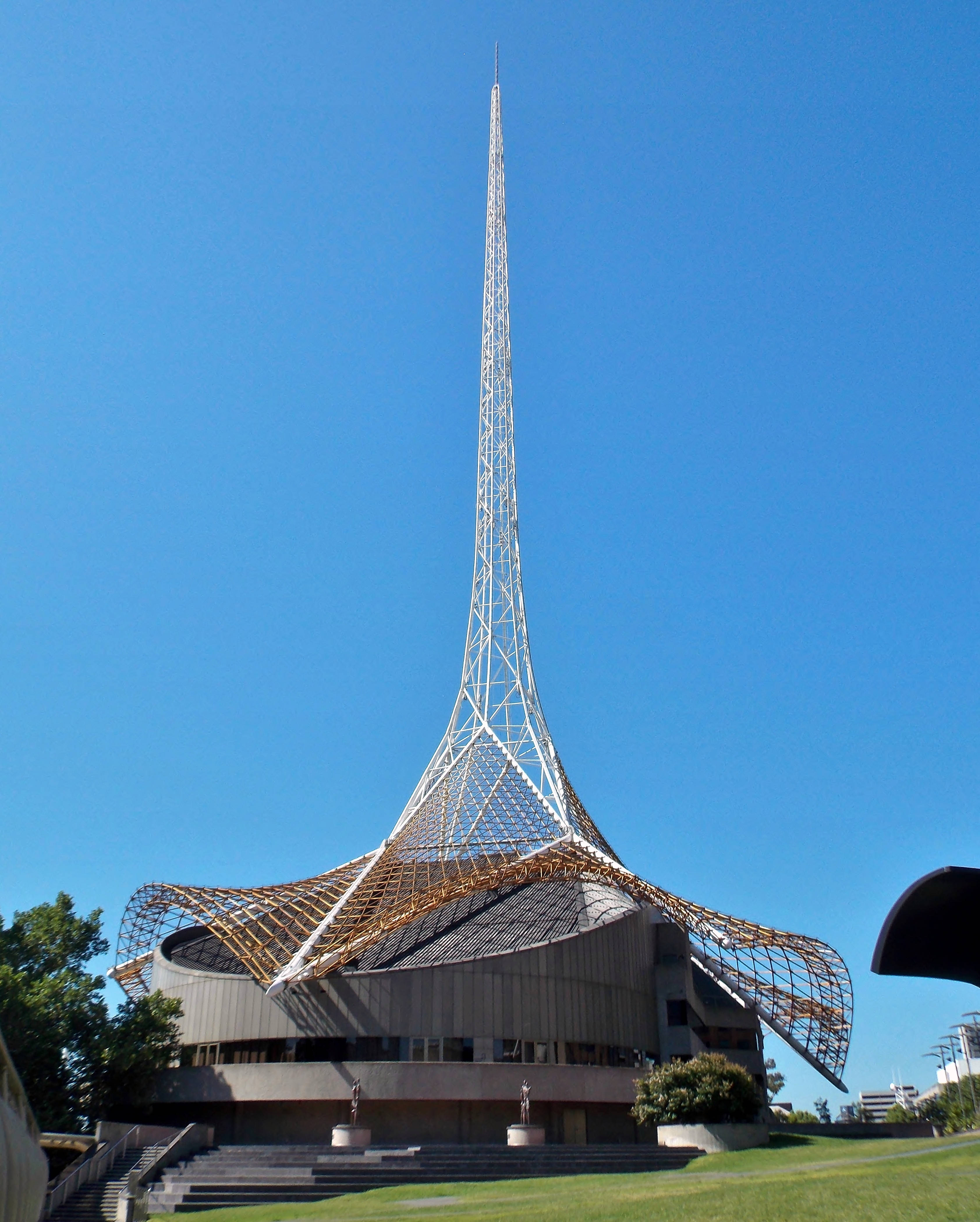 Melbourne 桌布 壁紙 — 一座引人注目的現代主義建築，擁有高聳的白色格子尖頂和弧形木屋頂，映襯著清澈的藍天。
